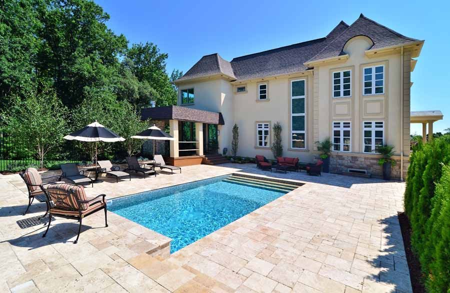 A large house with a large swimming pool in front of it