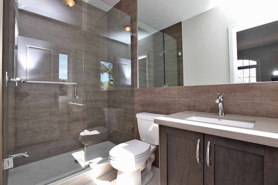 A bathroom with a toilet , sink , and shower.