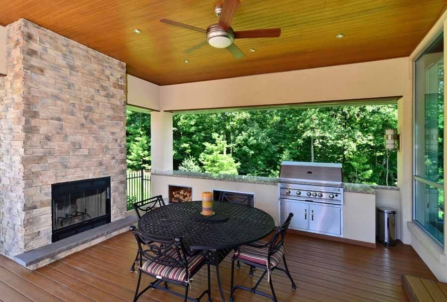 A patio with a table and chairs and a fireplace.