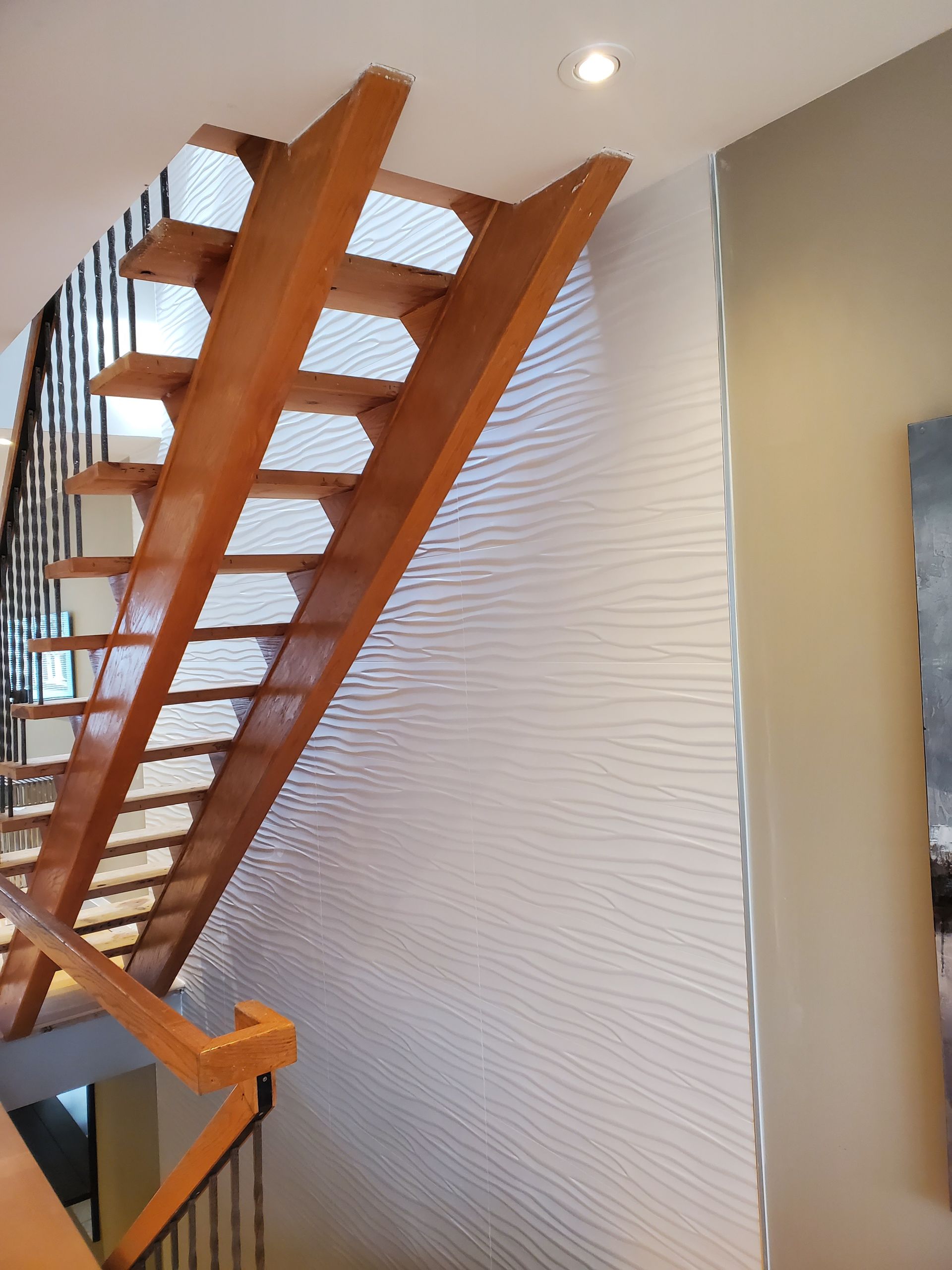 A wooden staircase with a white wall behind it