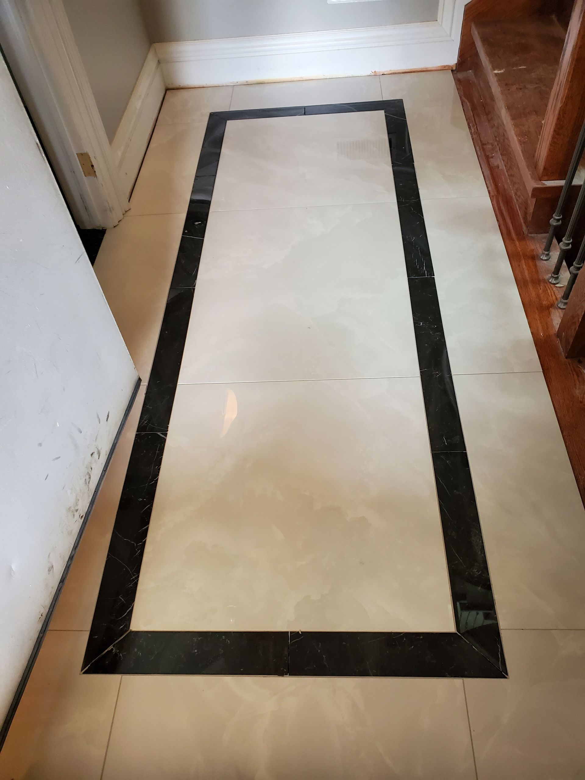 A marble floor with a black border in a hallway