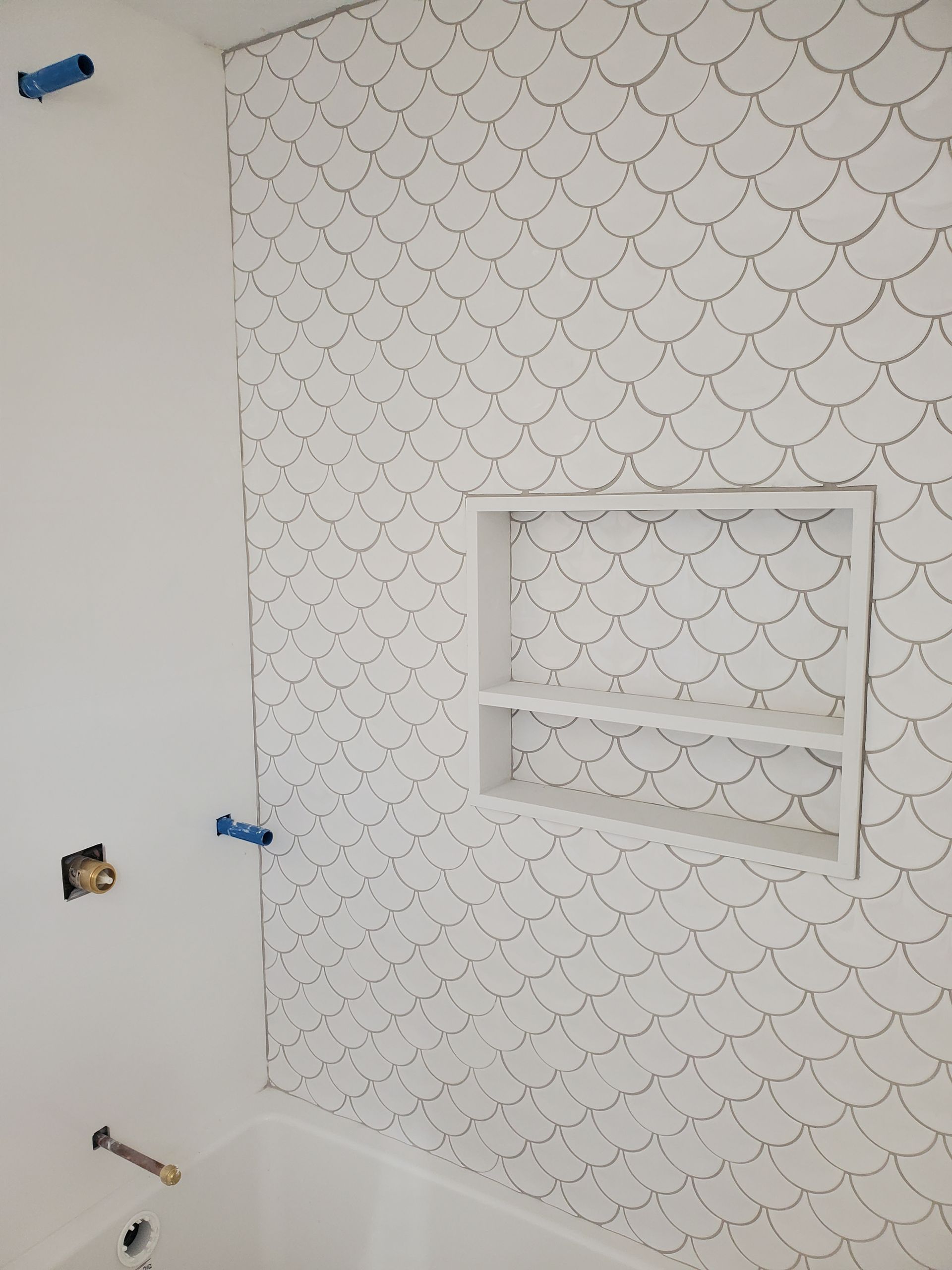 A bathroom with a mermaid scale pattern on the wall.