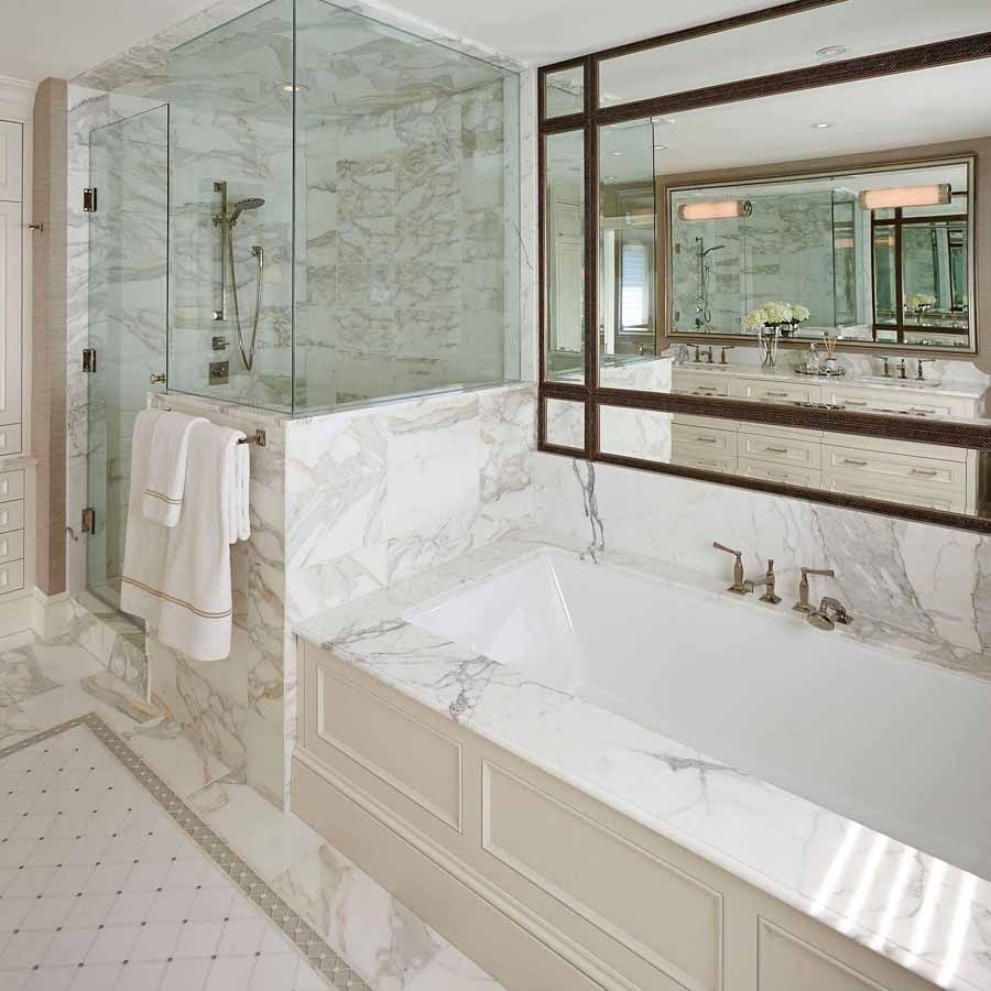 A bathroom with a bathtub and a large mirror