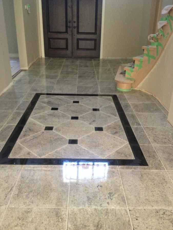 A hallway with a tiled floor and stairs in the background.