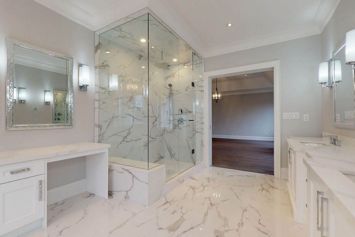 A bathroom with a walk in shower and two sinks.