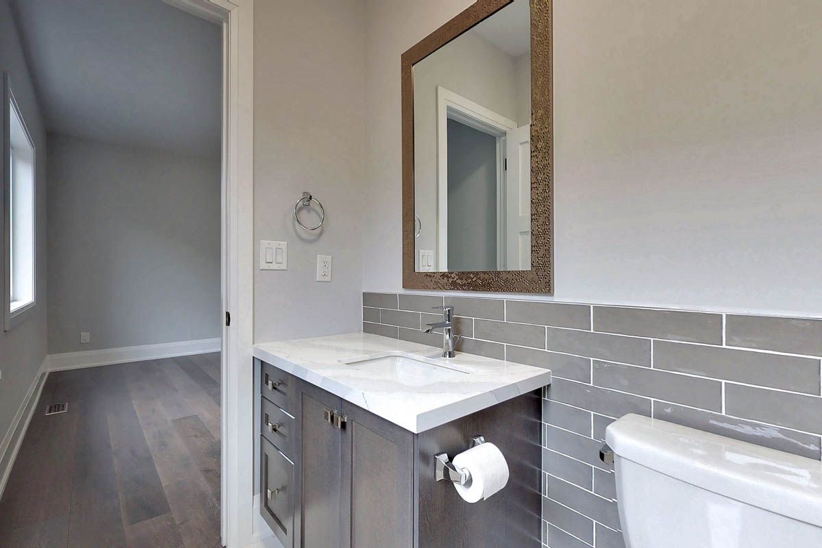A bathroom with a sink , toilet and mirror.