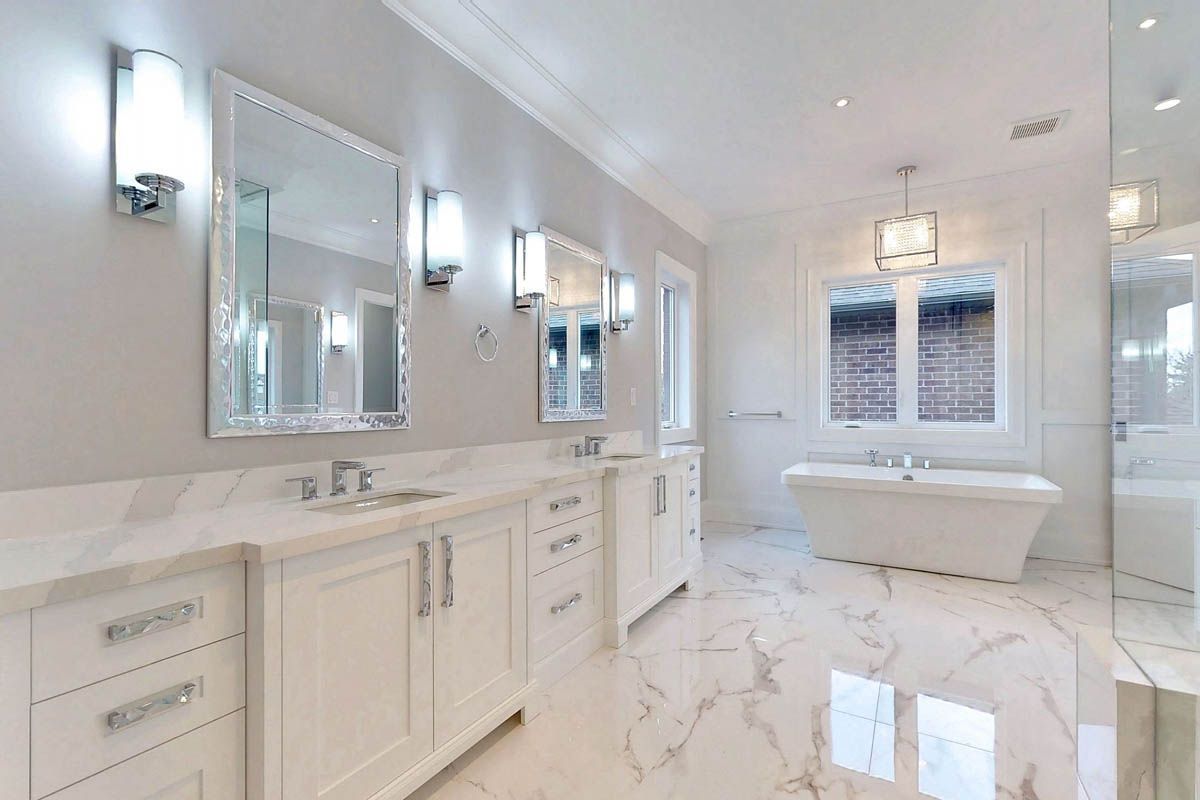A bathroom with two sinks , two mirrors , a tub and a walk in shower.