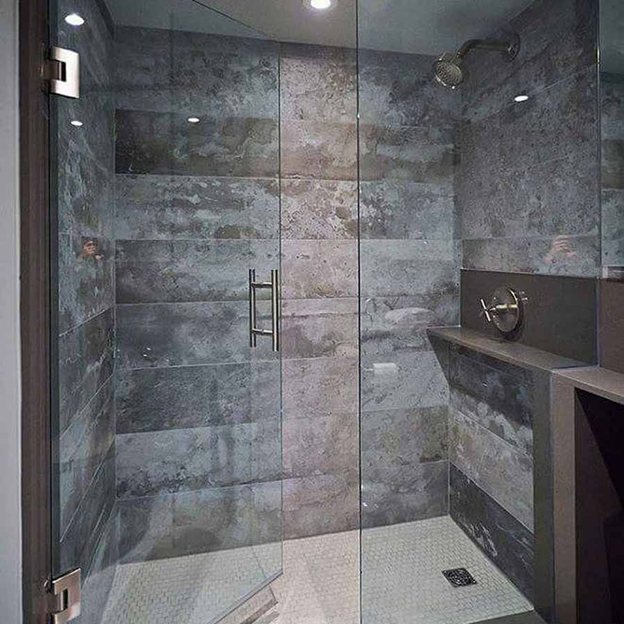 A bathroom with a walk in shower with a glass door