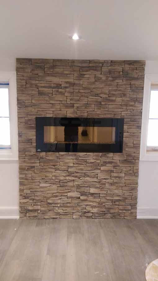 A fireplace is built into a stone wall in a living room.