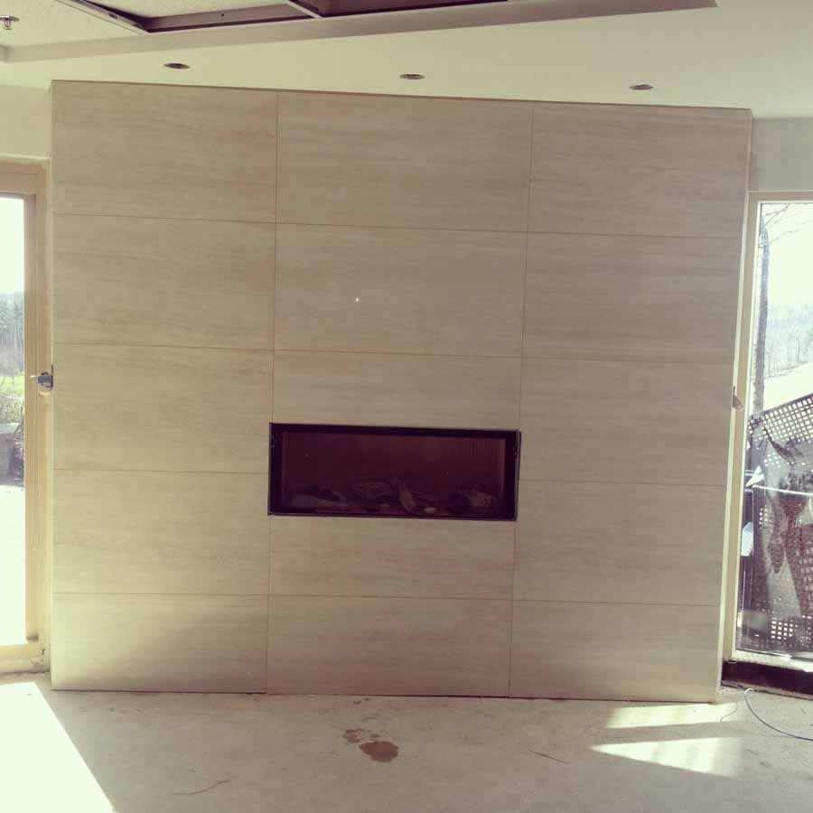 There is a fireplace in the middle of the wall.