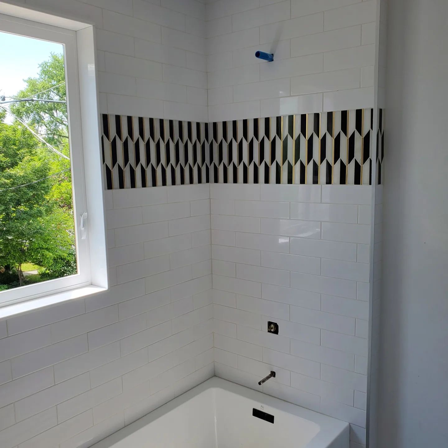 A bathroom with a bathtub and a window