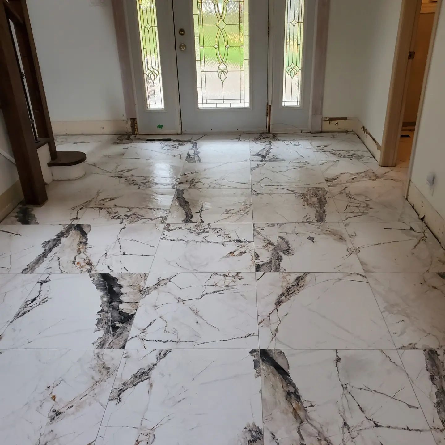 A marble floor with a door in the background
