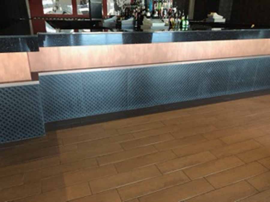 A counter in a restaurant with bottles of alcohol on it