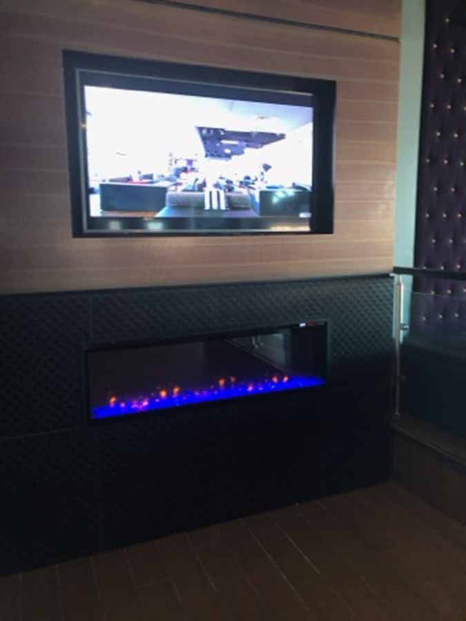 A flat screen tv is mounted on a wall above a fireplace