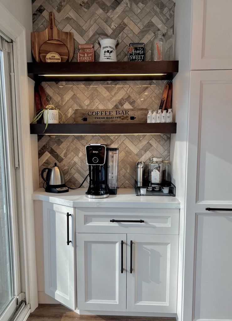 A kitchen with white cabinets and a coffee maker on the counter.