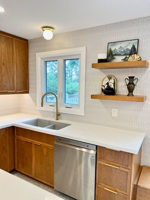 A kitchen with two sinks and a stainless steel dishwasher