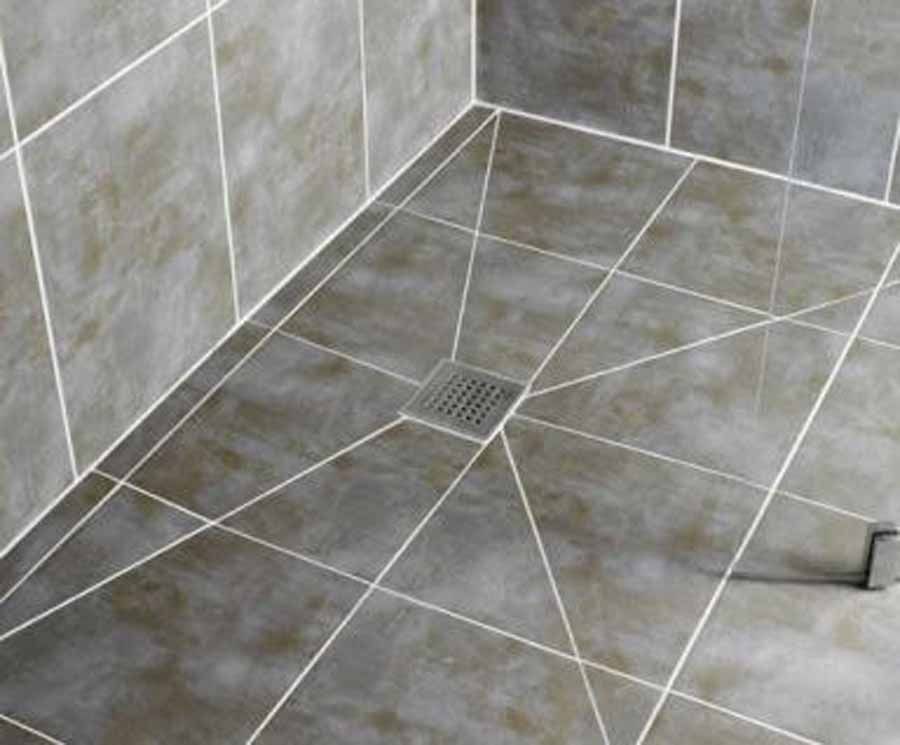 A tiled floor in a bathroom with a drain