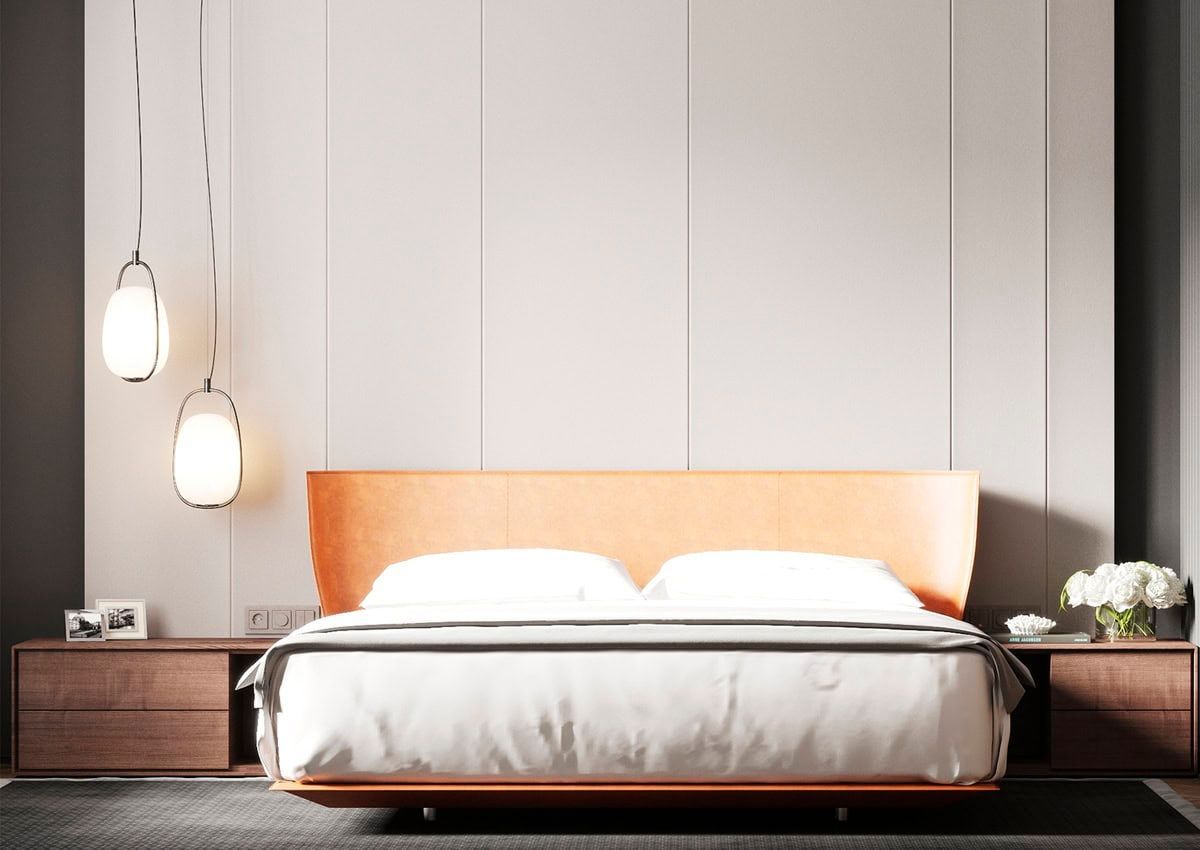 Camera da letto con letto, testiera arancione, due lampade a sospensione e comodini in legno.