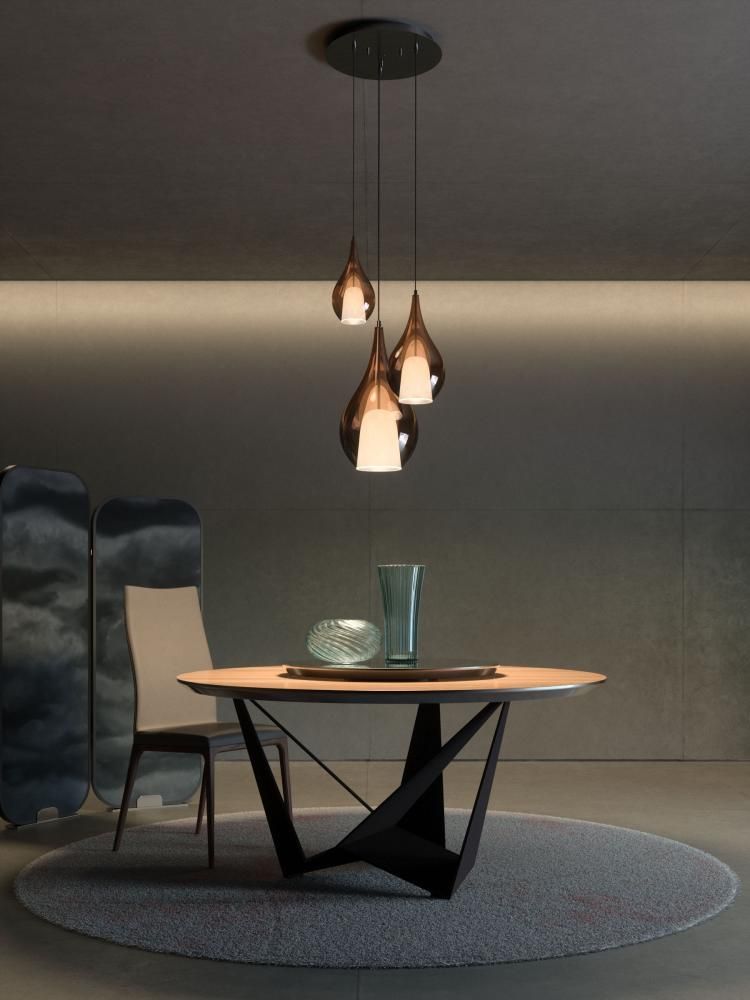 Sala da pranzo moderna con lampade a sospensione sopra un tavolo rotondo.