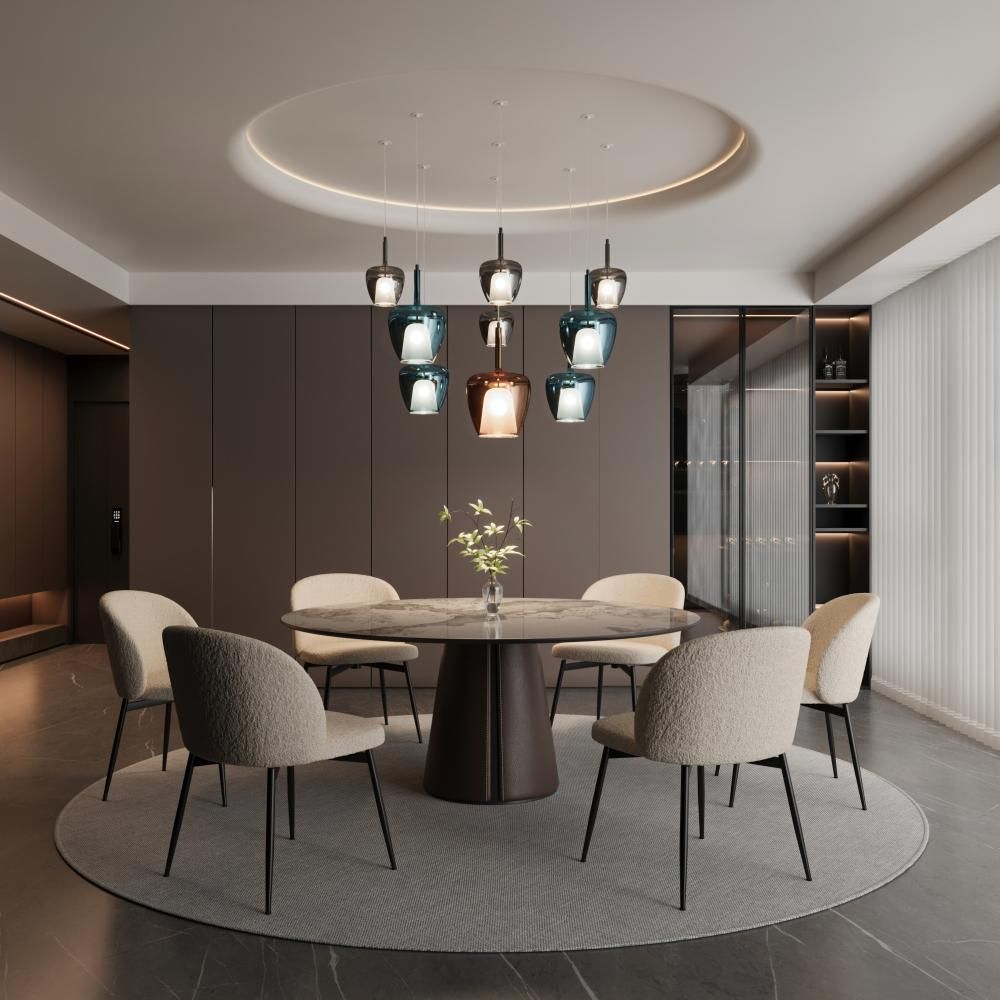 Sala da pranzo con tavolo rotondo, sedie e un lampadario unico.