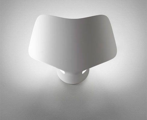 Lampada da tavolo bianca dal design moderno, con paralume ampio e curvo, che proietta una luce soffusa sulla superficie.