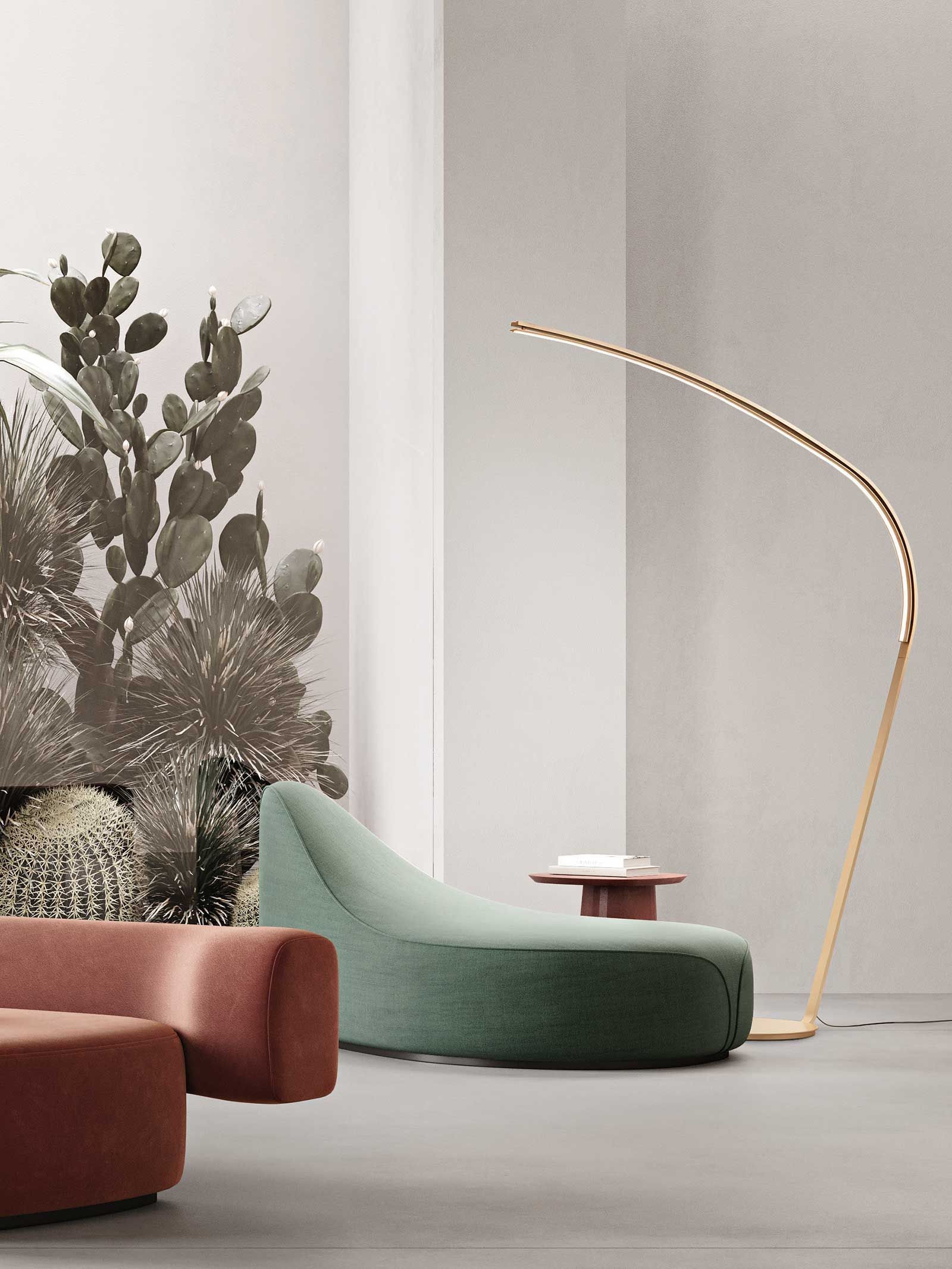 Interni moderni con chaise longue verde, lampada da terra e murale di cactus.