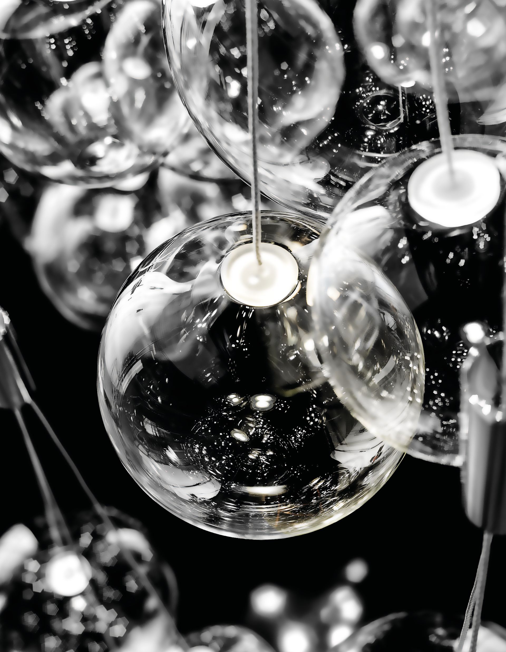 Le luci a globo in vetro trasparente sono appese su uno sfondo scuro.