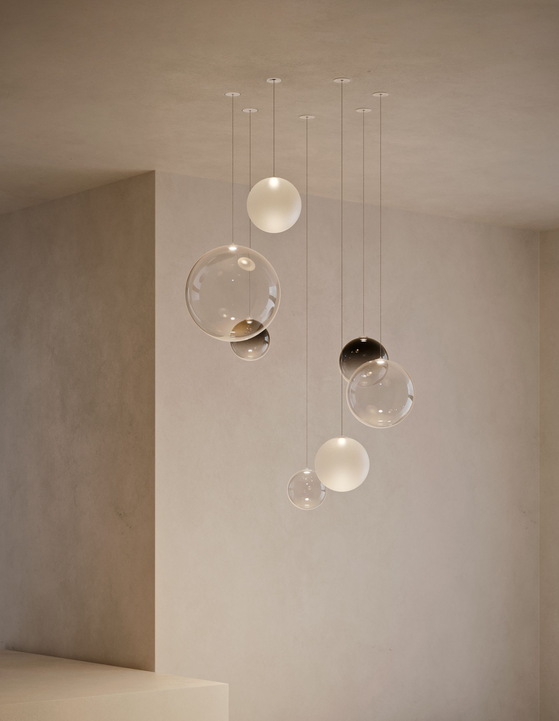 Lampadario moderno con globi di vetro trasparente e satinato appesi al soffitto.