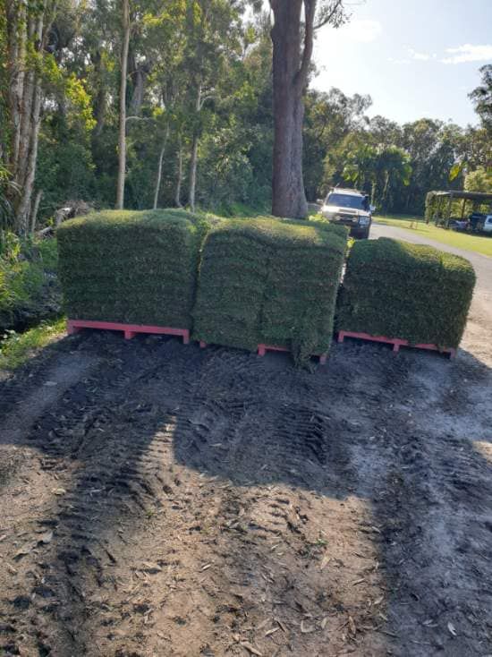 A Truck is Driving Down a Dirt Road Next to a Pile of Grass — Ballina Turf Farm in Wardell, NSW