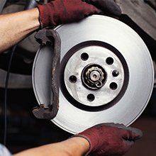 A person is holding a brake disc in their hands.