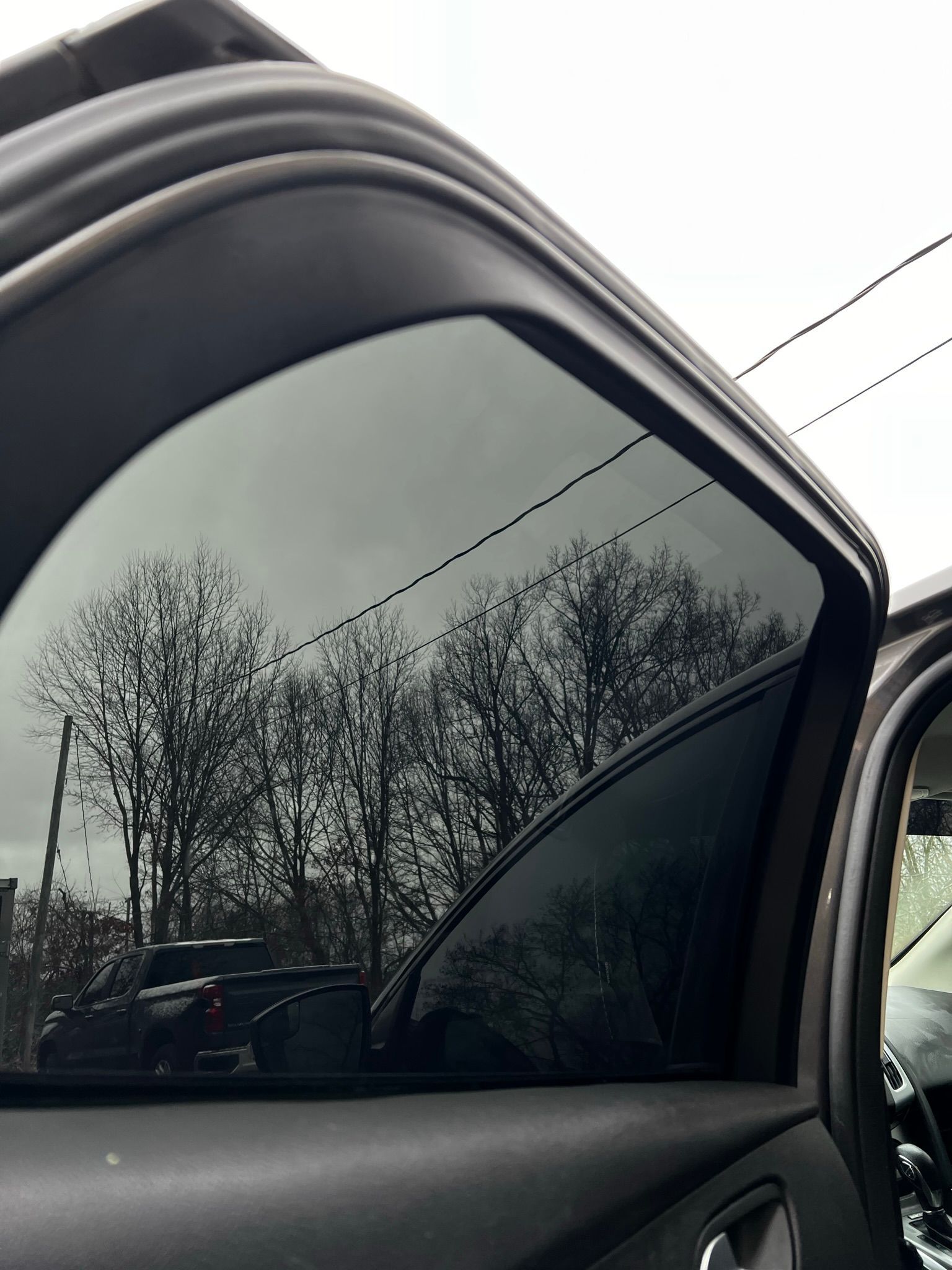 A car with a reflection of trees in the window