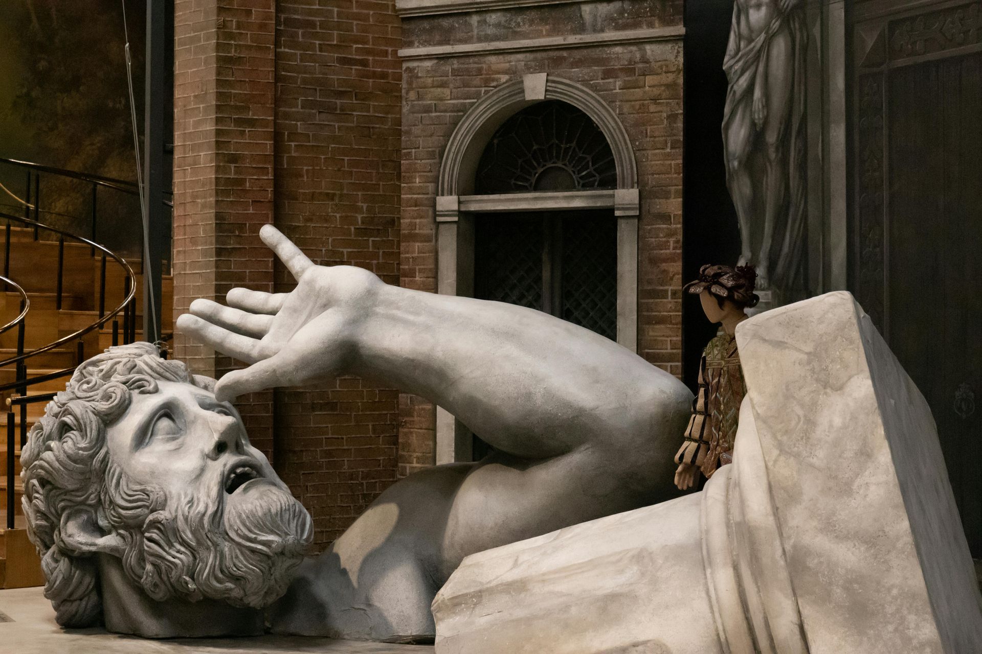 A statue of a man with a beard is laying on the ground.