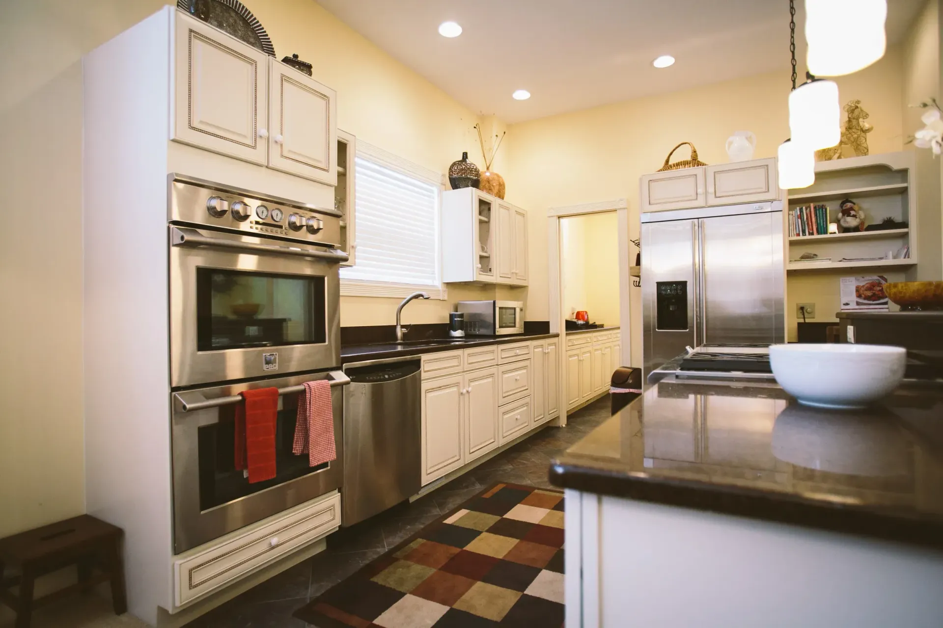 Kitchen with white cabinets, stainless steel appliances, and a dark countertop.