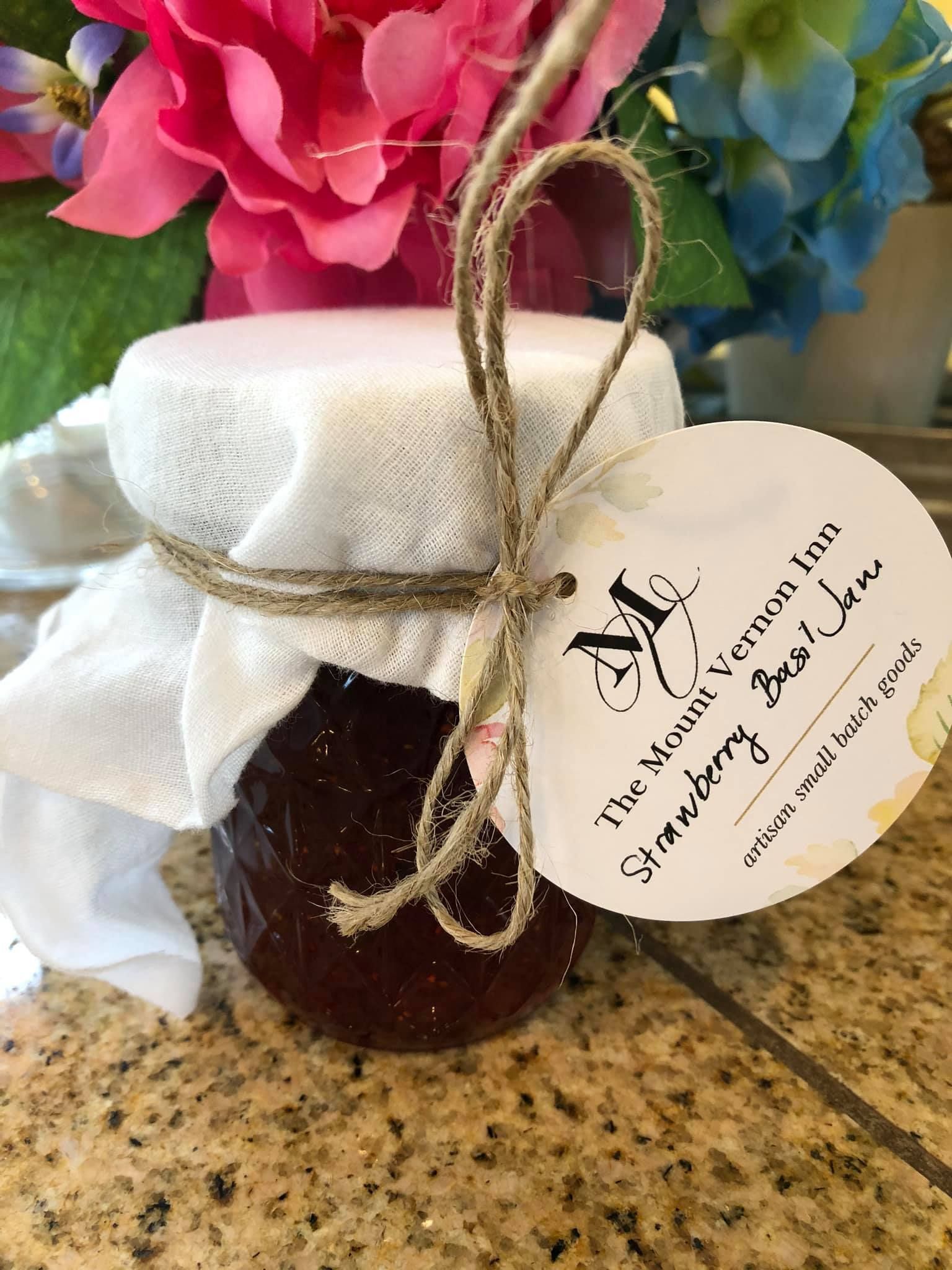 Jar of strawberry basil jam with a tag tied with twine.
