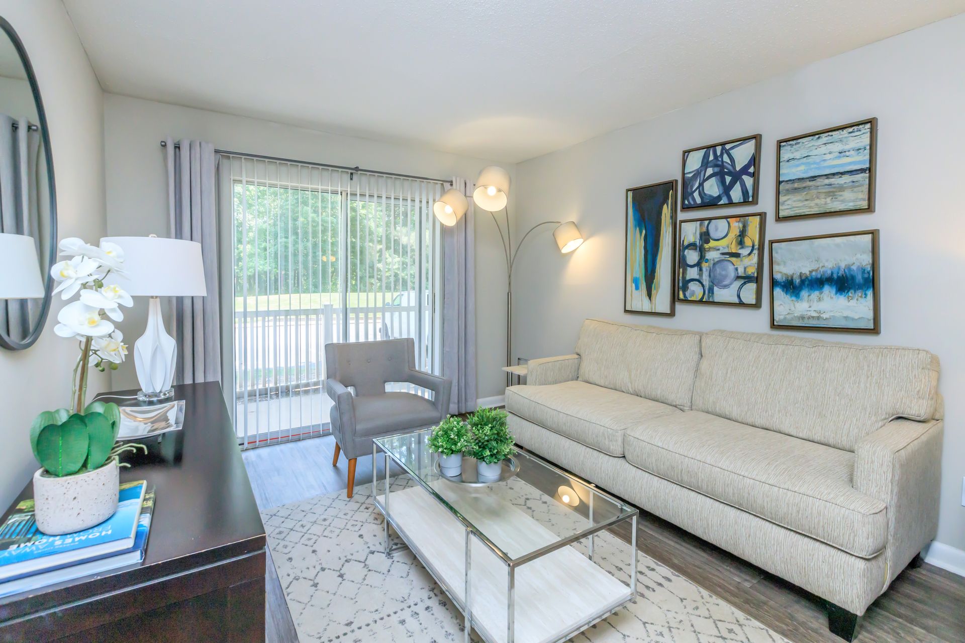 A living room with a couch , chair , coffee table and sliding glass doors.
