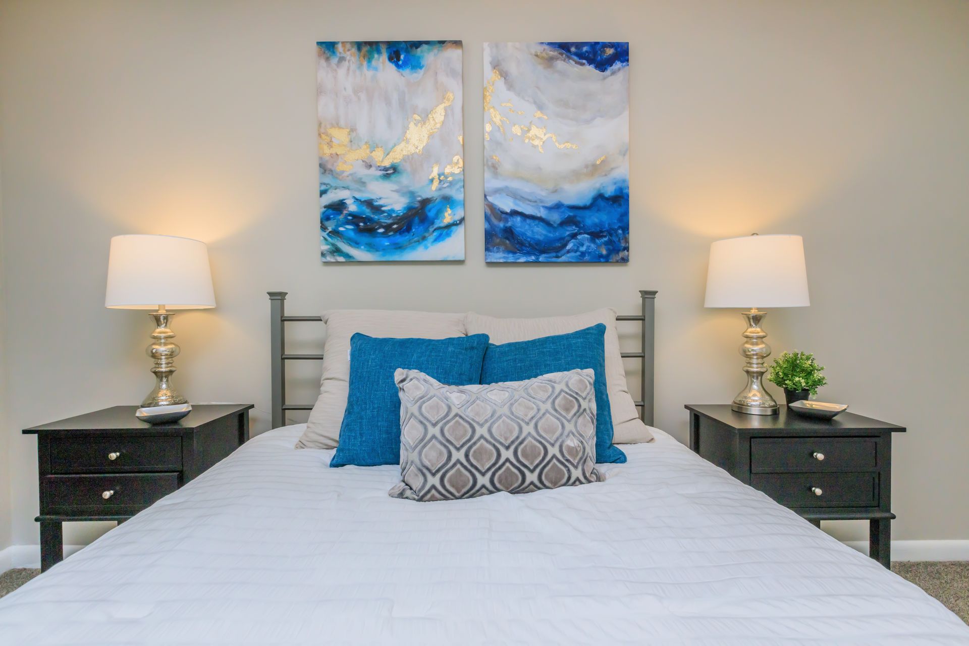 There are two paintings on the wall above the bed.