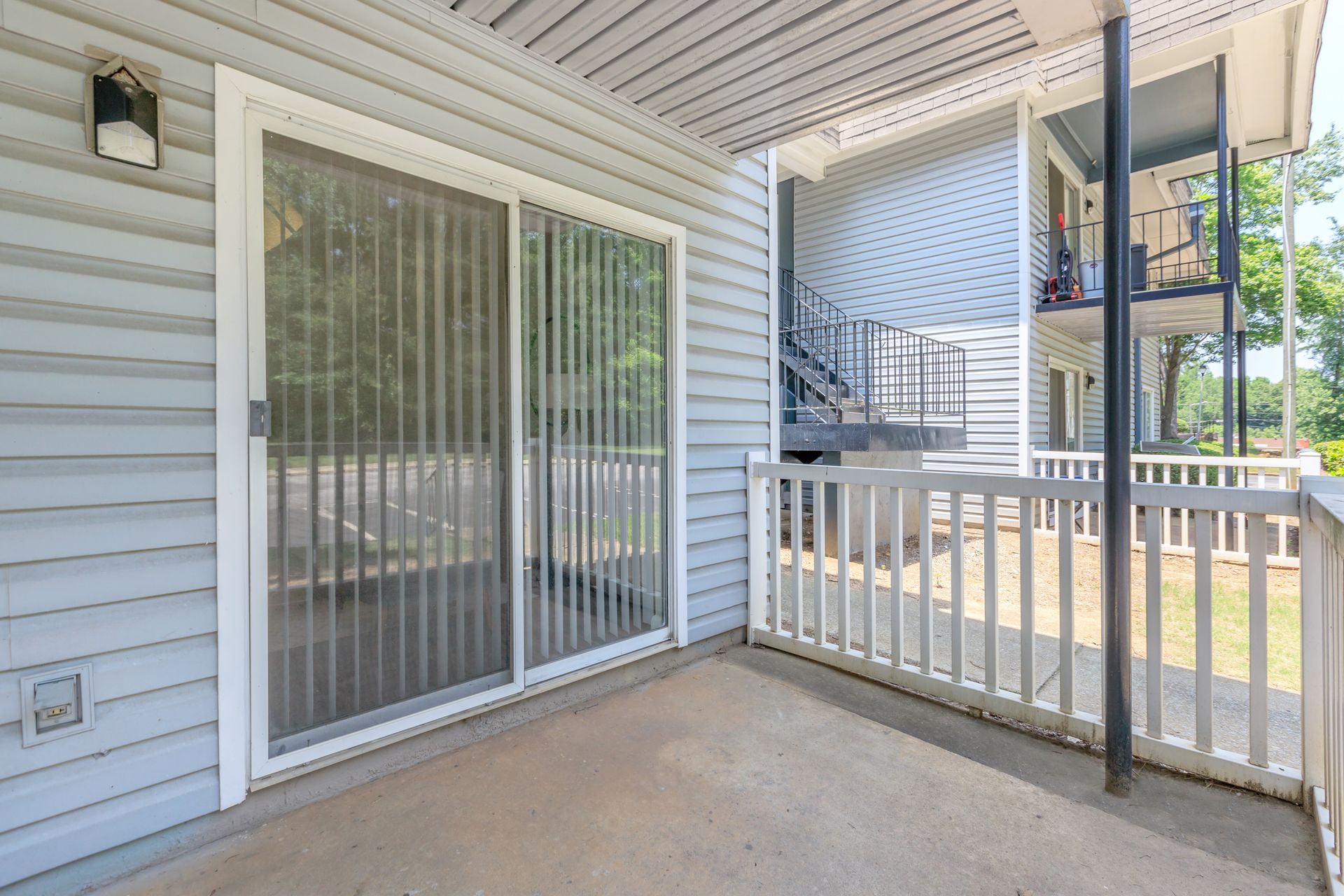 A balcony with a sliding glass door and a railing.