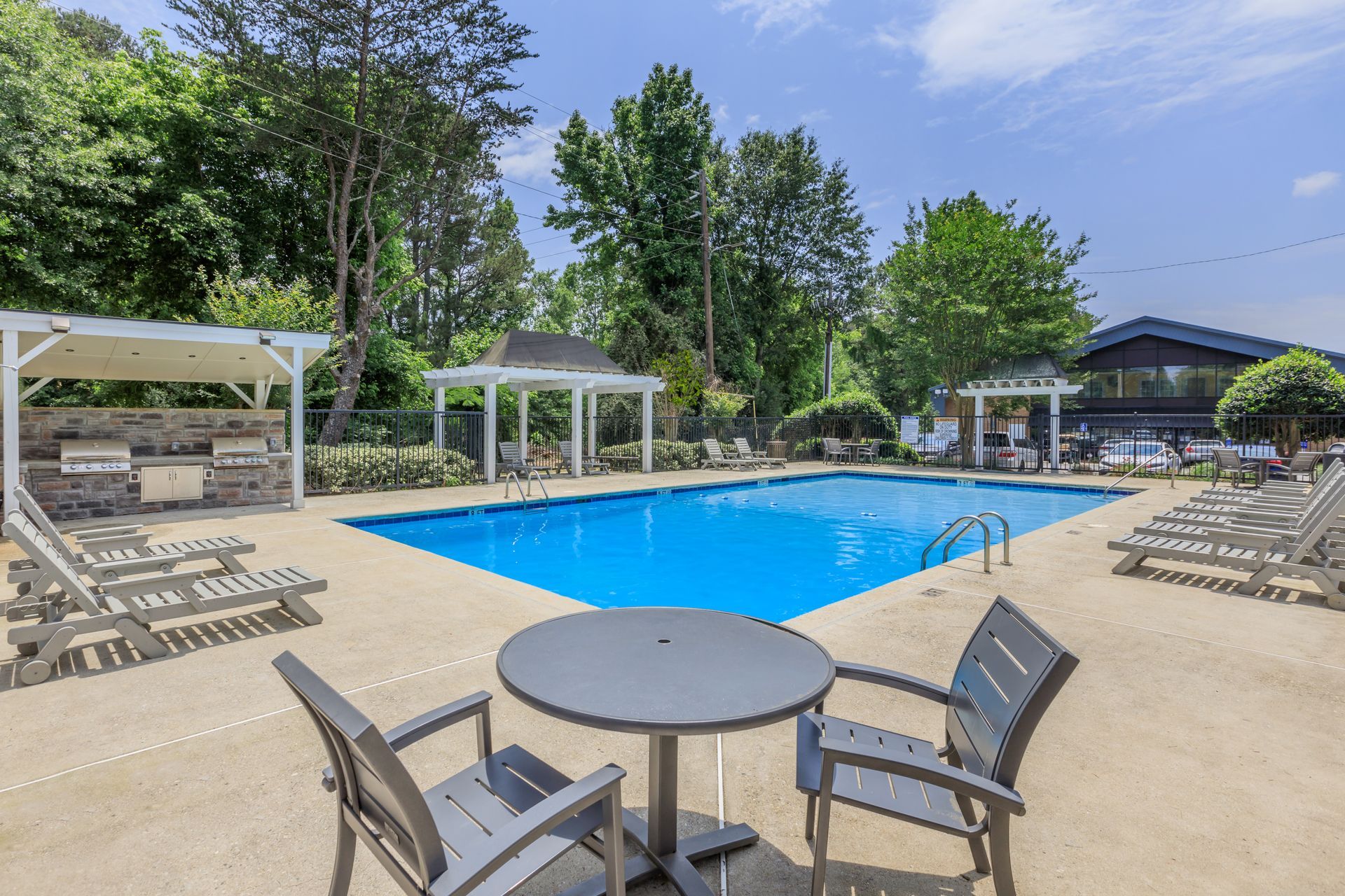 A swimming pool with a table and chairs around it.