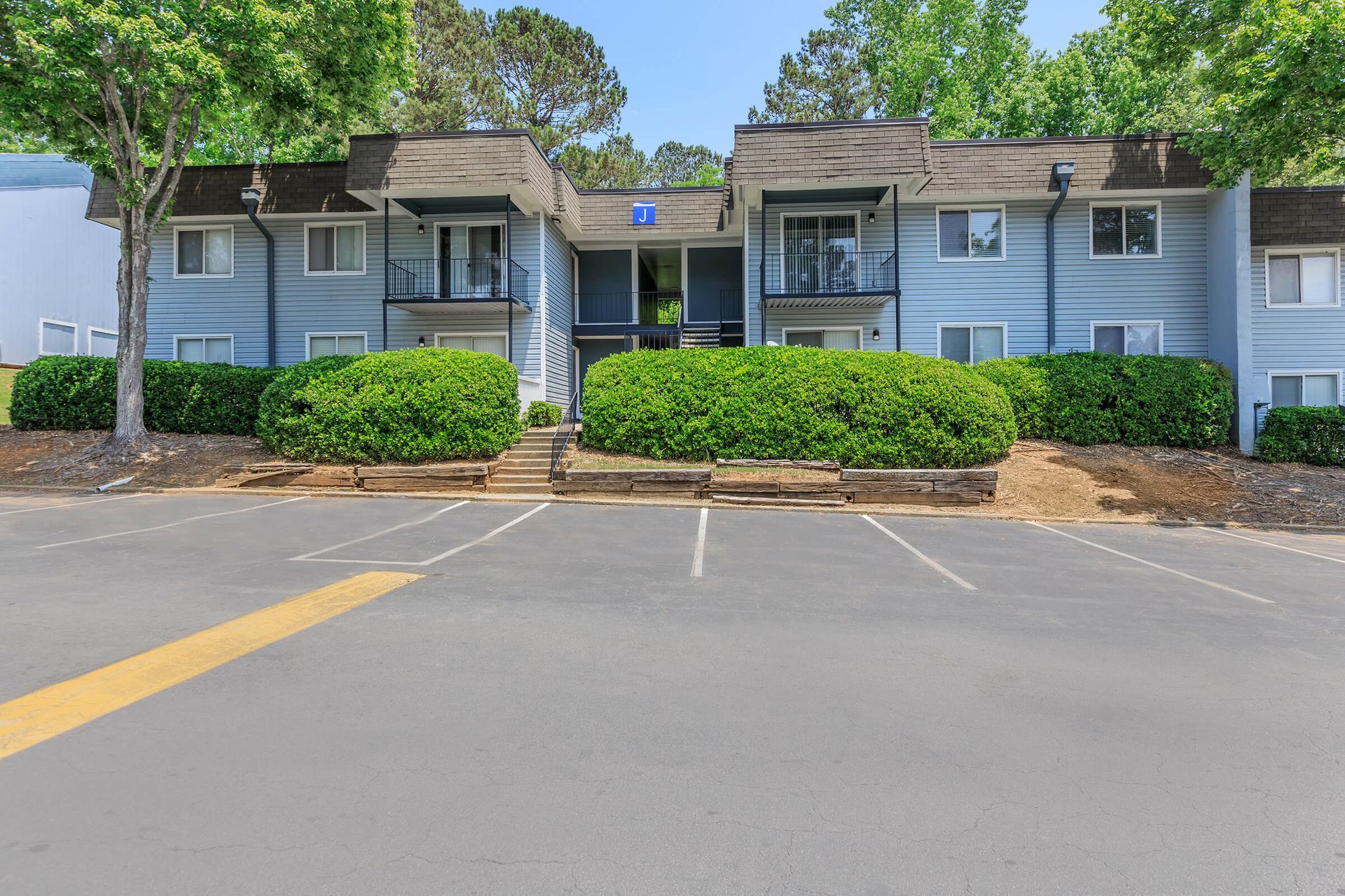 A large apartment building with a parking lot in front of it.