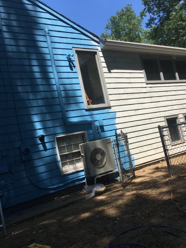 A blue and white house with an air conditioner on the side