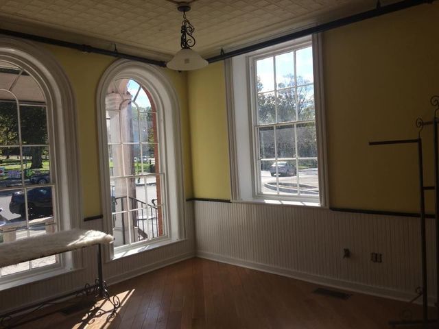 An empty room with yellow walls and white trim