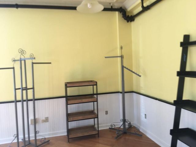 A room with yellow walls and black shelves