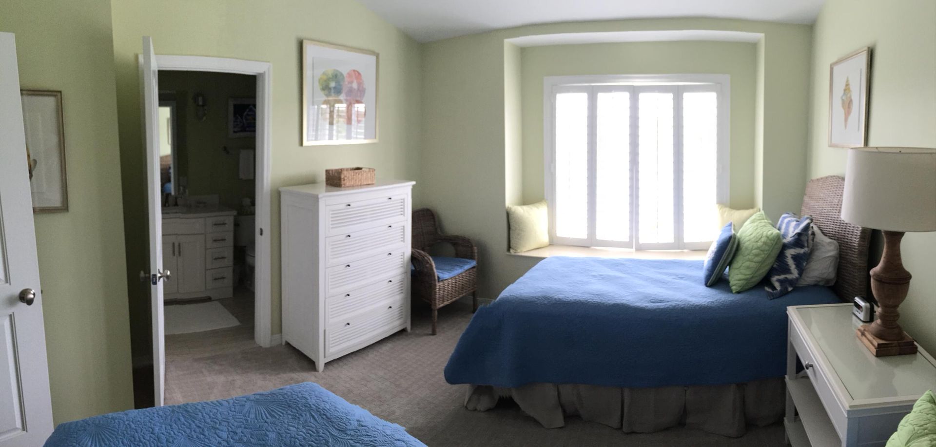 A bedroom with two beds , a dresser , and a window.