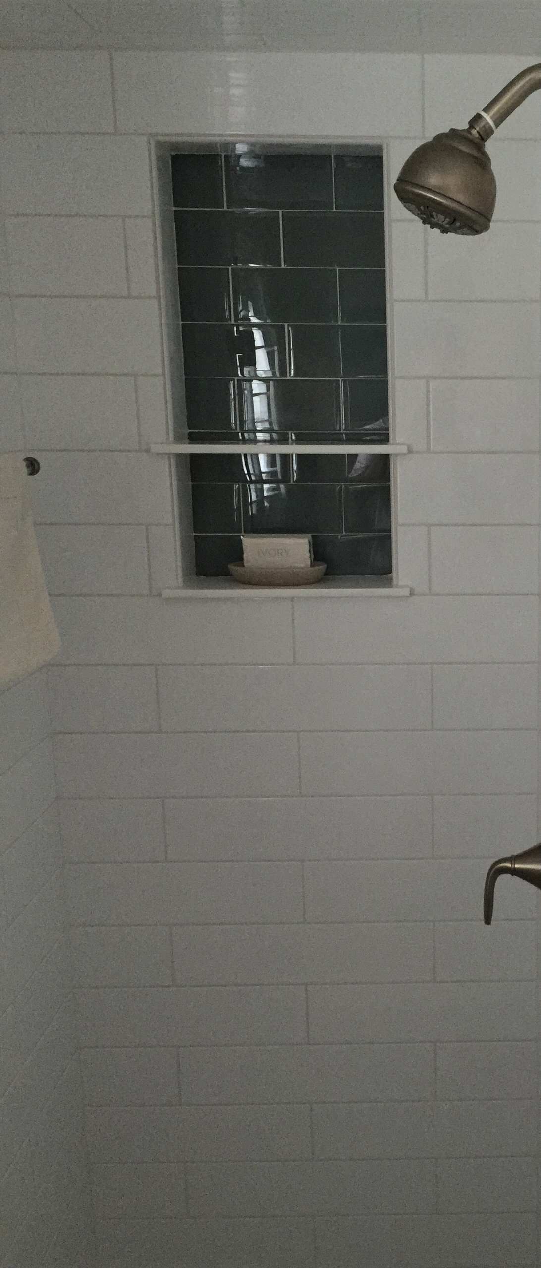 A shower with a window and a shower head.