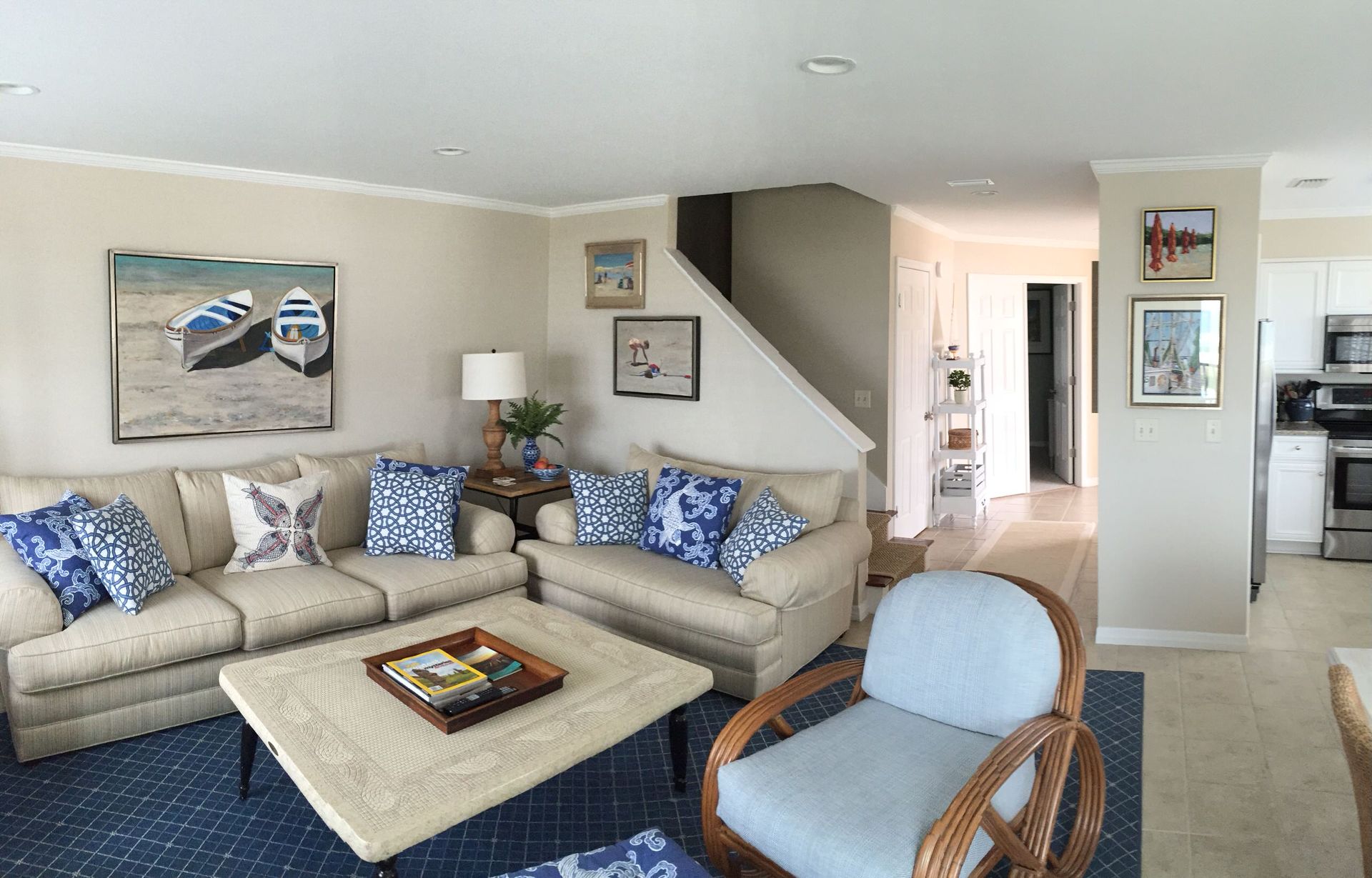 A living room with a couch , chair , coffee table and stairs.