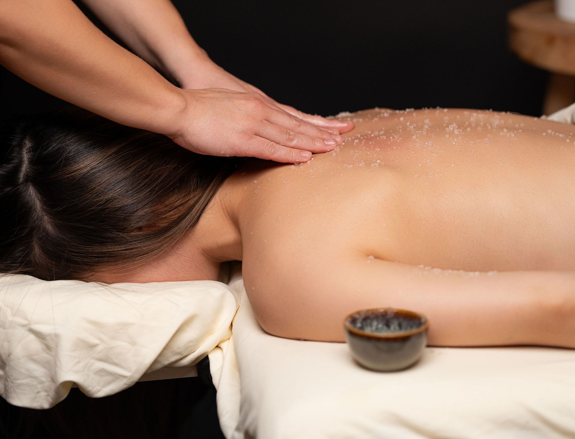 Eine Frau liegt auf einem Tisch und bekommt eine Massage.