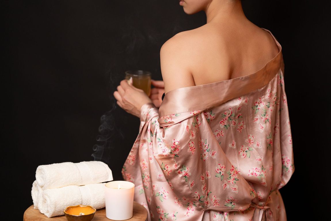 Eine Frau im Bademantel hält eine Tasse Tee.