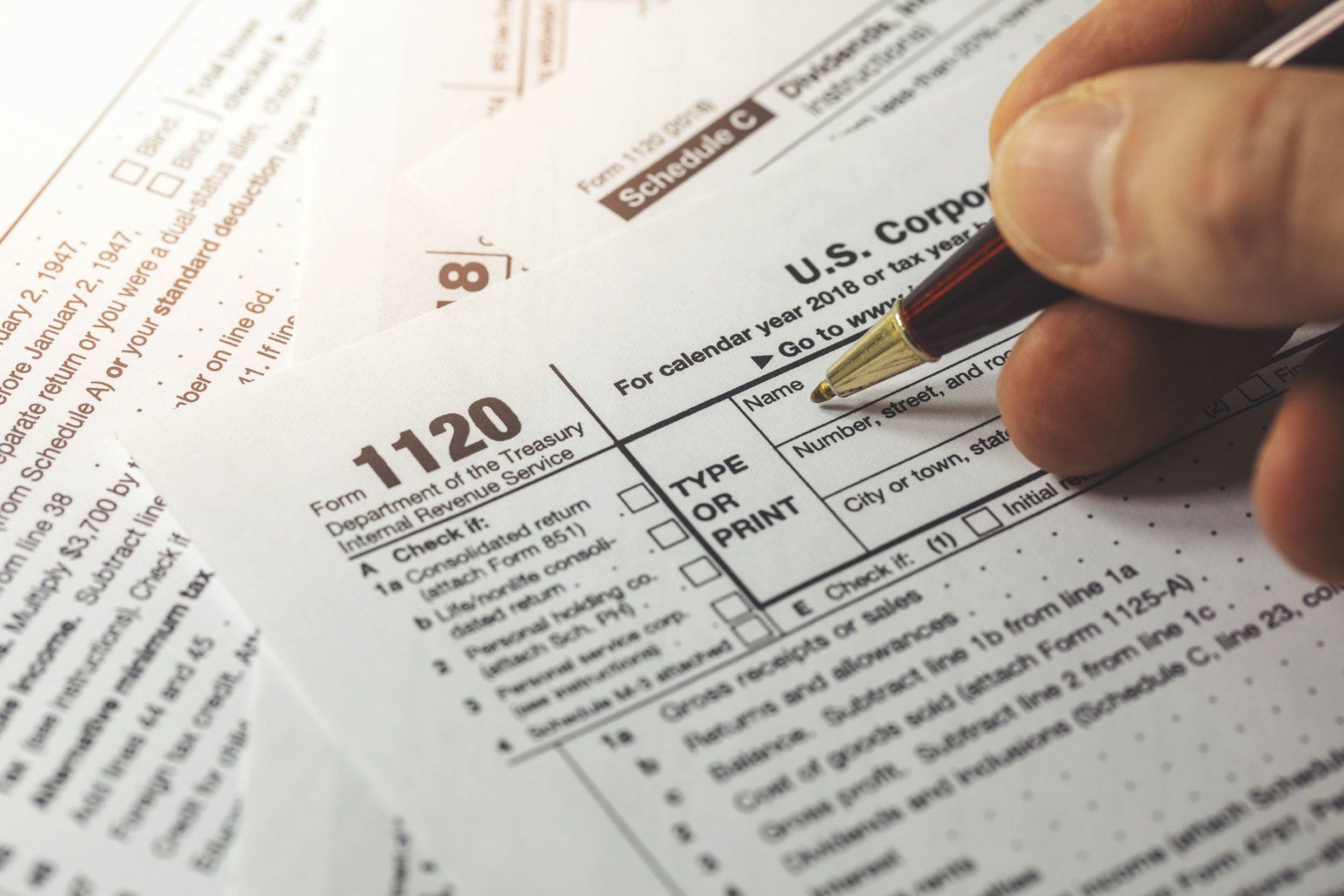 Man Signing Form 1120 — Hot Springs, AR — Hutchison Tax Service