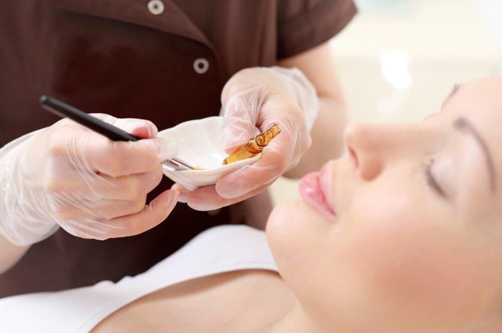 A woman is getting a facial treatment at a beauty salon.