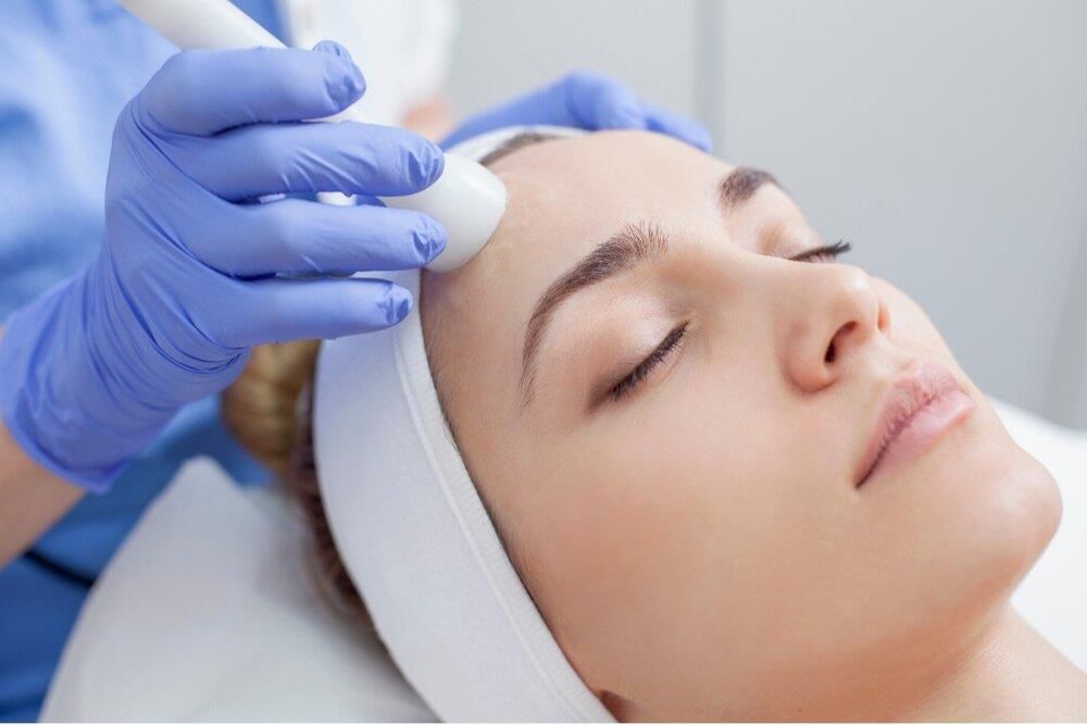 A woman is getting a facial treatment at a beauty salon.